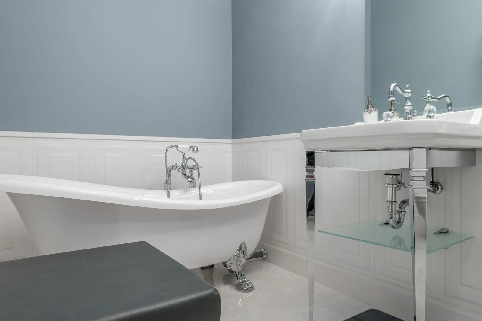 Interior of stylish bathroom with empty white bathtub and sink in luxury modern flat