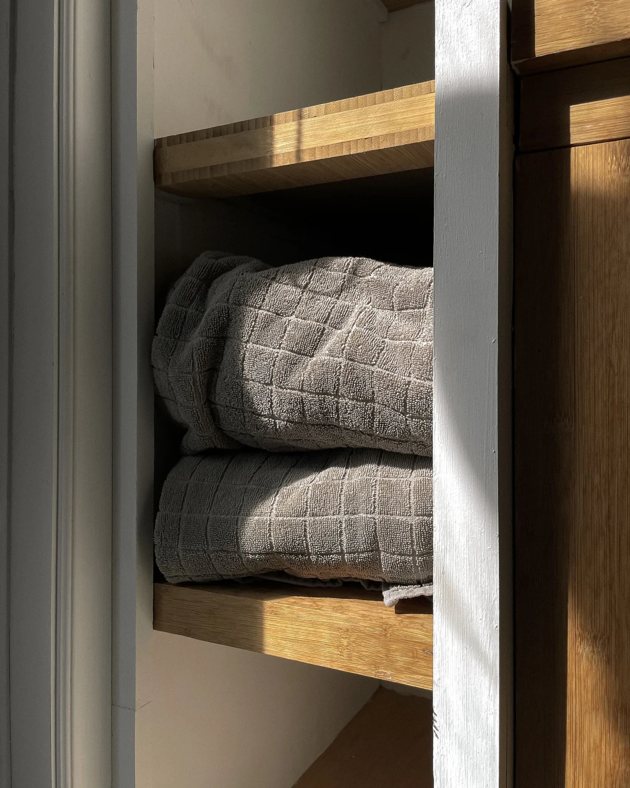 Folded towels on recessed shelves