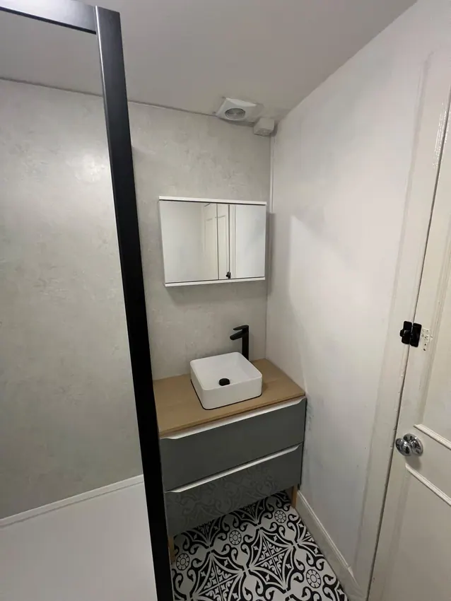 Grey drawer vanity with countertop basin and mirrored cabinet